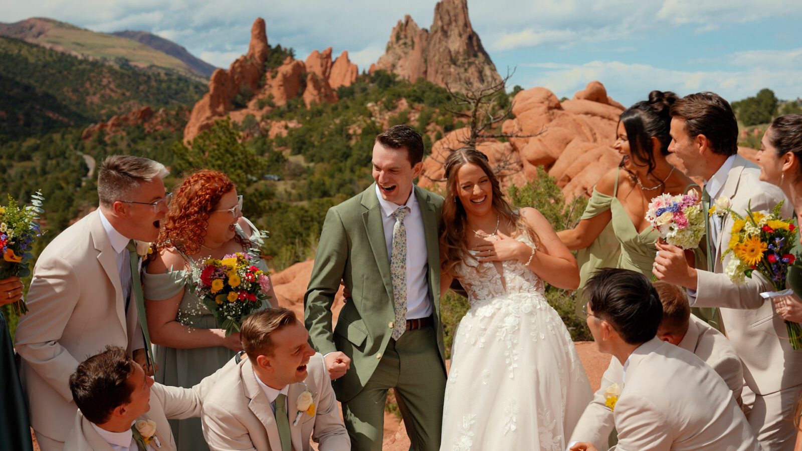 Couple laughing with their wedding party among the red rock formations at Garden of the Gods.