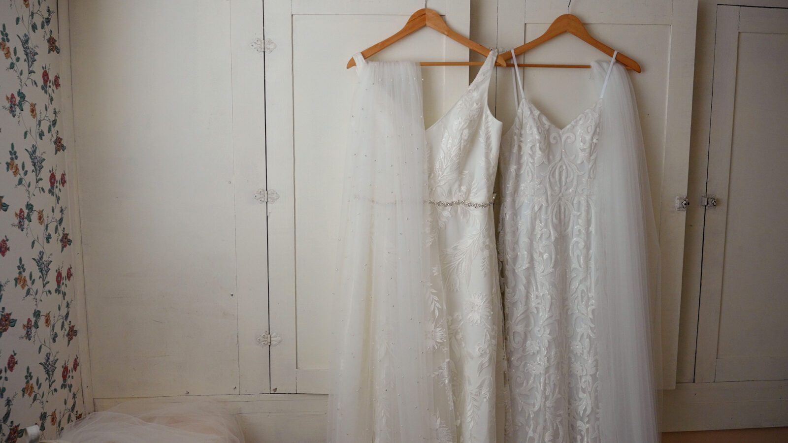 Two white wedding dresses hanging side by side inside District 5 Schoolhouse.