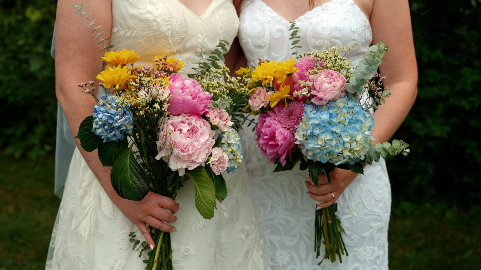 Close-up of colorful DIY wedding bouquets with pink, yellow, and blue flowers.